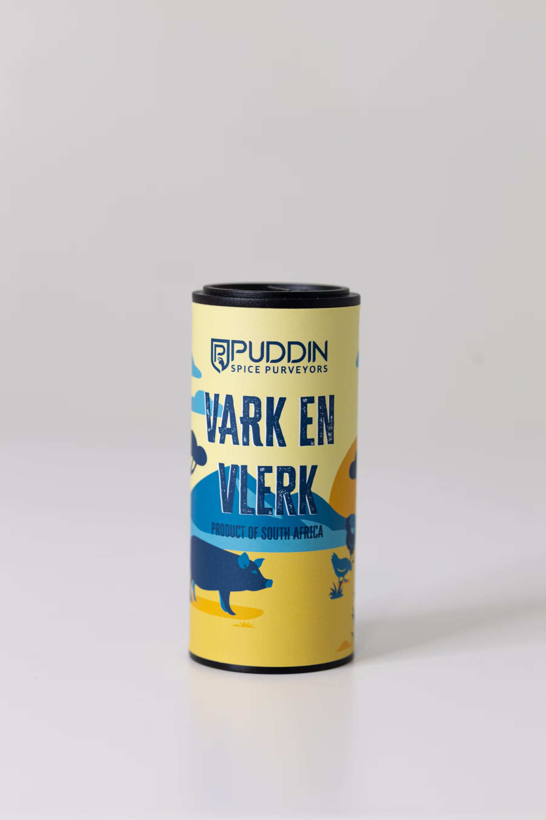 A cylindrical tin of Puddin Spice Surveyors 'Vark en Vlerk' (pig and wing) seasoning, featuring a yellow and blue label with illustrations of a pig, set against a plain light gray background.